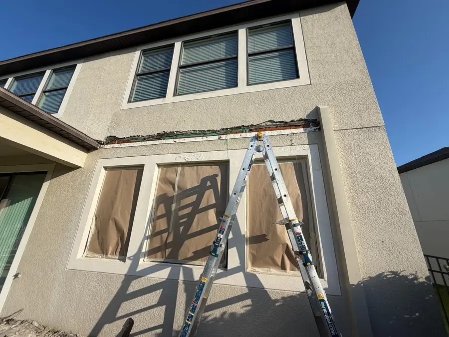 Damaged stucco band cut out below second story windows during a ZLS stucco repair